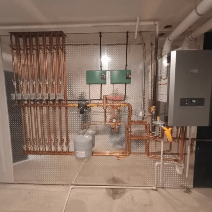 Complex residential boiler system installation with vertical copper pipes and zoned heating controls.