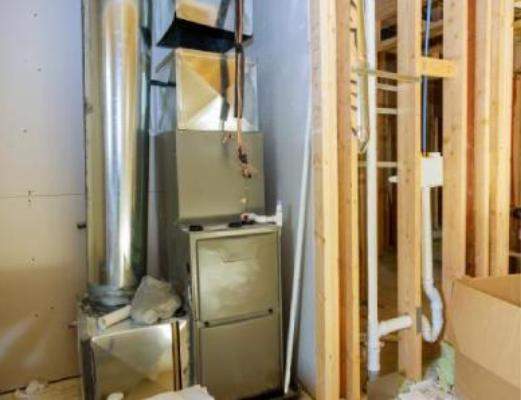 Residential gas furnace unit installed in an unfinished basement mechanical room.